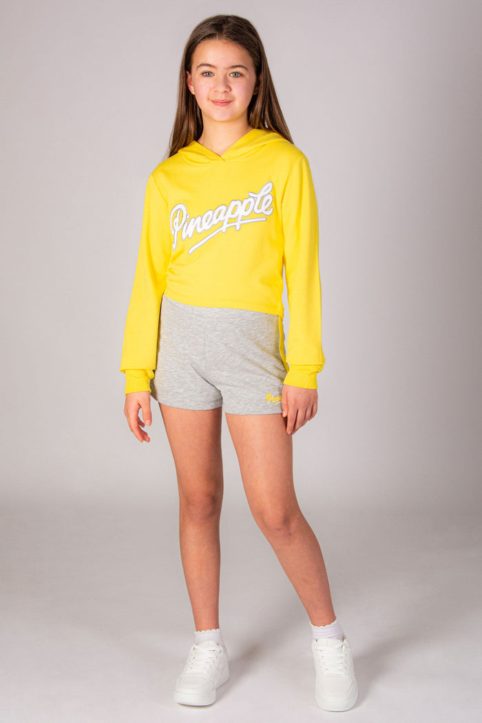 Girls' yellow hoodie with Pineapple Dance Studios chest logo print.