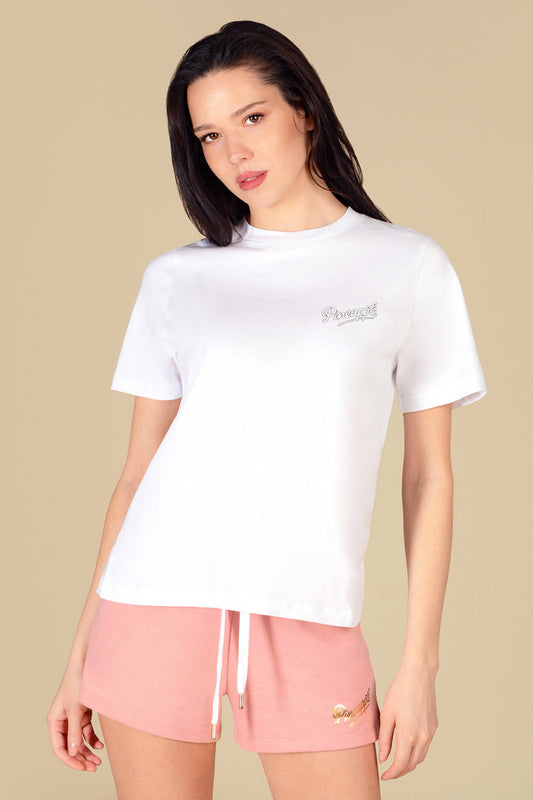 Woman wearing a regular fit white t-shirt with light pink sporty shorts against a light yellow background.