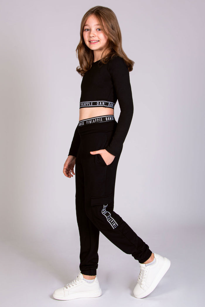 Shop cotton cargo joggers for kids paired with a cropped long sleeve dance top from Pineapple, London