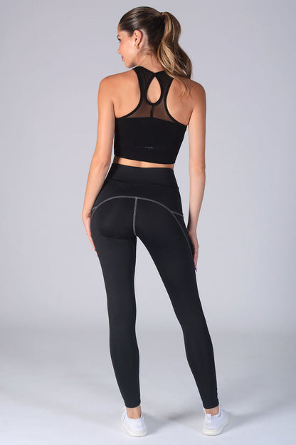 Woman wearing black Leggings with pockets and black vest top with keyhole back