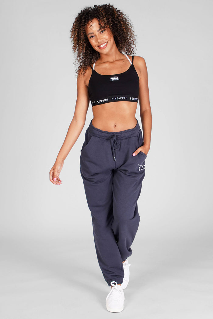 Woman wearing Charcoal Oversized Pocket Joggers with logo and Black Bra Top