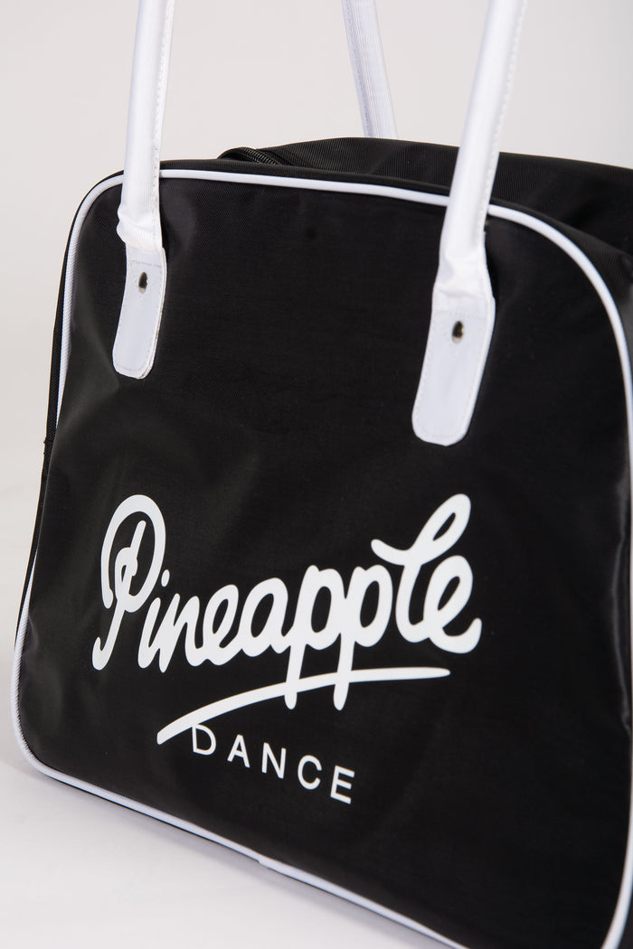 Black duffle bag with 'Pineapple Dance' logo on a white background