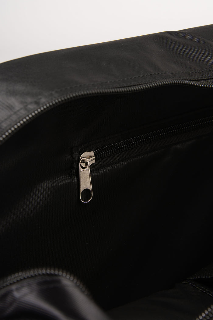 Close-up of a black bag with a zipper and inside pocket on a white background
