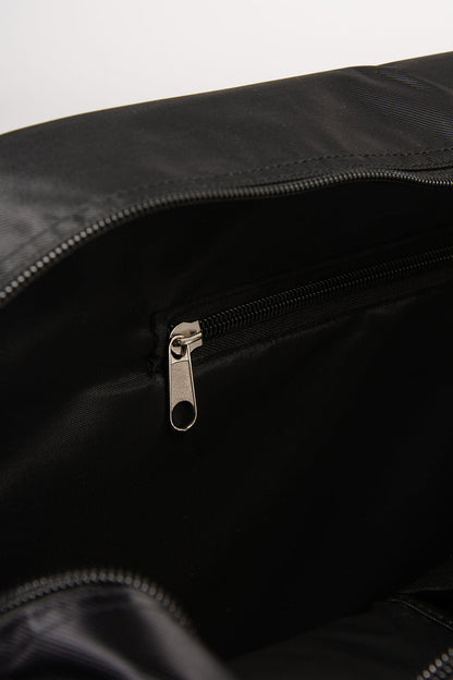 Close-up of a black bag with a zipper and inside pocket on a white background
