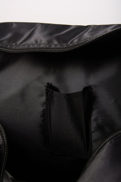 Close-up of a black bag with a zipper and phone pocket on a white background