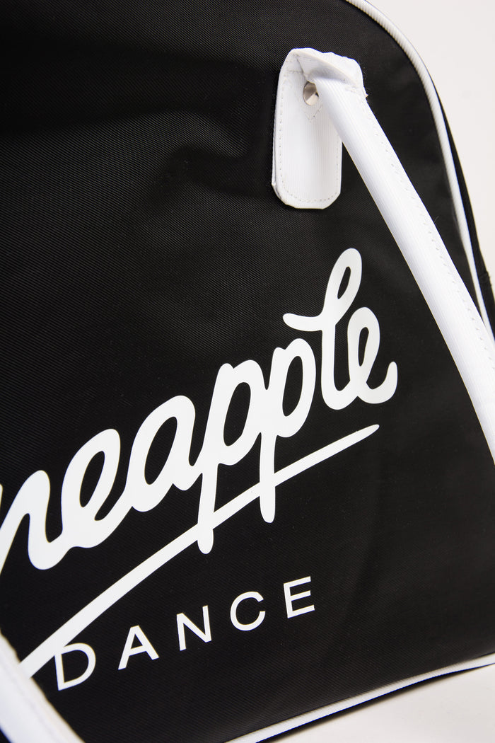 Close up of a black bag with 'Pineapple Dance' logo on a white background