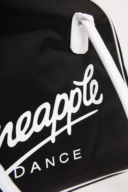 Close up of a black bag with 'Pineapple Dance' logo on a white background