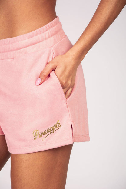 Light pink sporty shorts with pockets on a white background