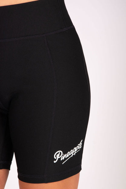 Black rib cycling shorts with elasticed waistband and small white branding on the left leg.
