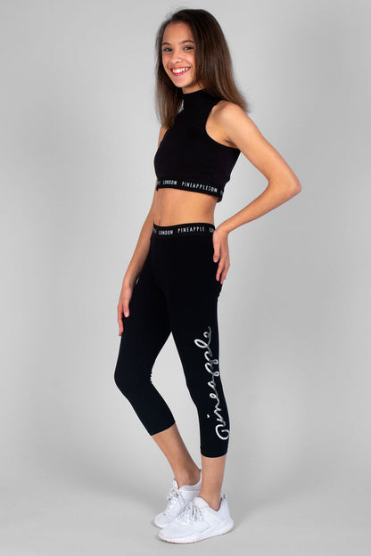 Girl wearing black Script Crop Leggings and black Barbarella Crop Top