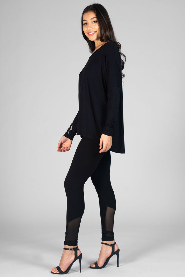 Woman wearing black Logo Long Sleeve Top and black leggings with mesh panels