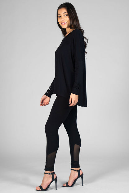 Woman wearing black Logo Long Sleeve Top and black leggings with mesh panels
