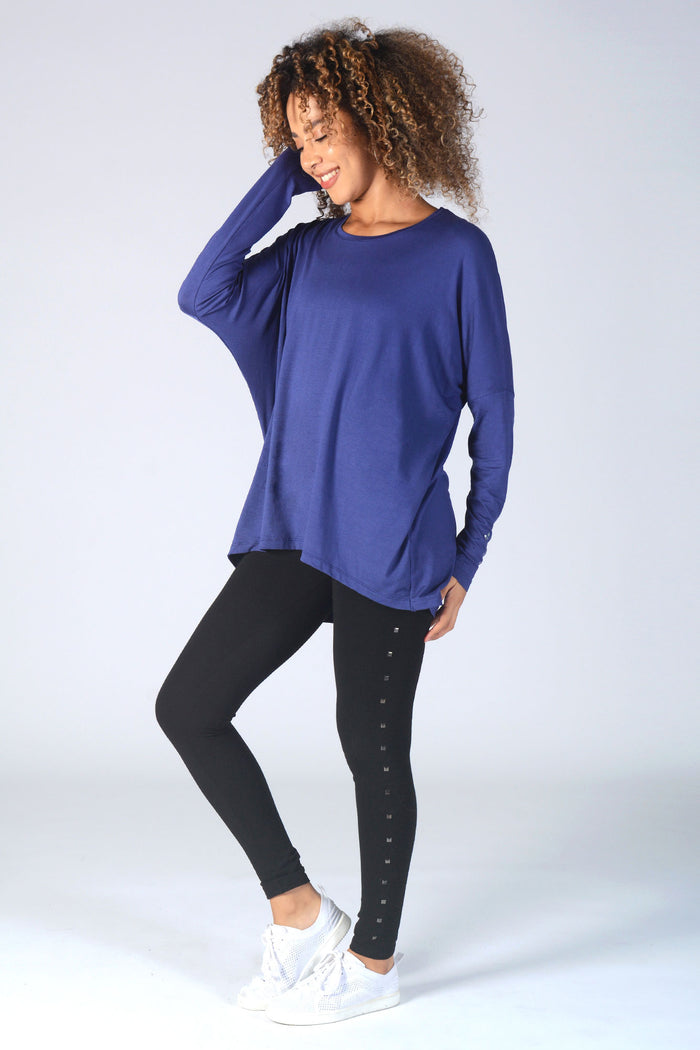 Woman wearing wide neck navy Long Sleeve T-Shirt with cuff logo and black studded leggings