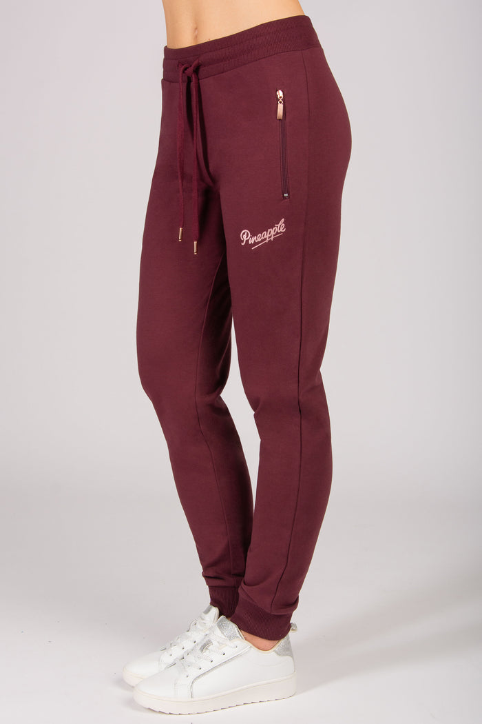 Women's burgundy skinny zip joggers with side zip pockets and drawstrings