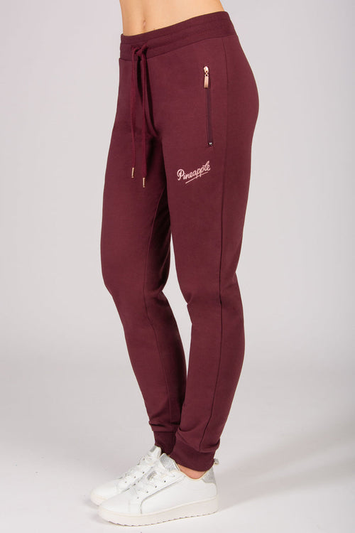 Women's burgundy skinny zip joggers with side zip pockets and drawstrings