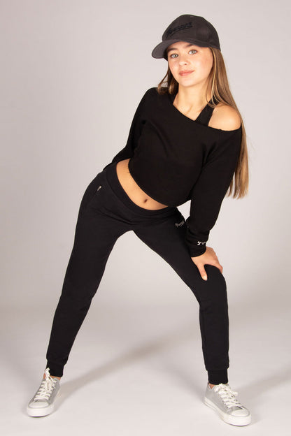 Teen's black skinny joggers with two zip pockets worn with off-shoulder sweat top