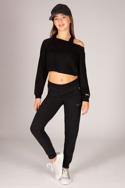 Teen's black skinny joggers with two zip pockets worn with off-shoulder sweat top