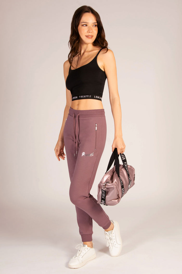 Women's raisonette joggers made of soft cotton-rich fabric featuring concealed side pockets and elasticated waistband.