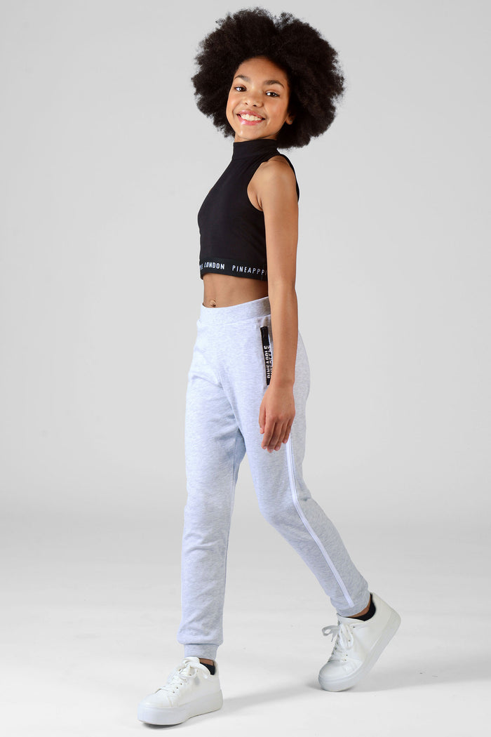 Girl wearing grey Joggers with white stripes and crop Barbarella black top