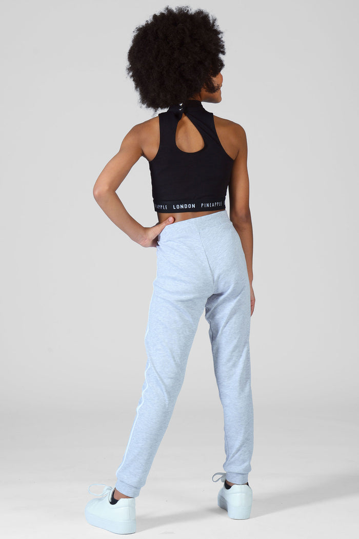 Girl wearing grey Joggers and crop black top with keyhole back