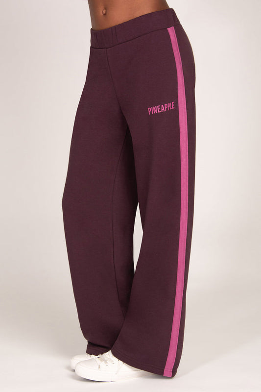 Maroon brown trousers with pink side panel and 'Pineapple' branding on a white background
