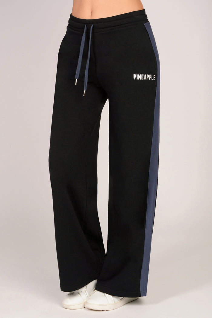 Black sweatpants with dark grey drawstring and side panels on a light grey background