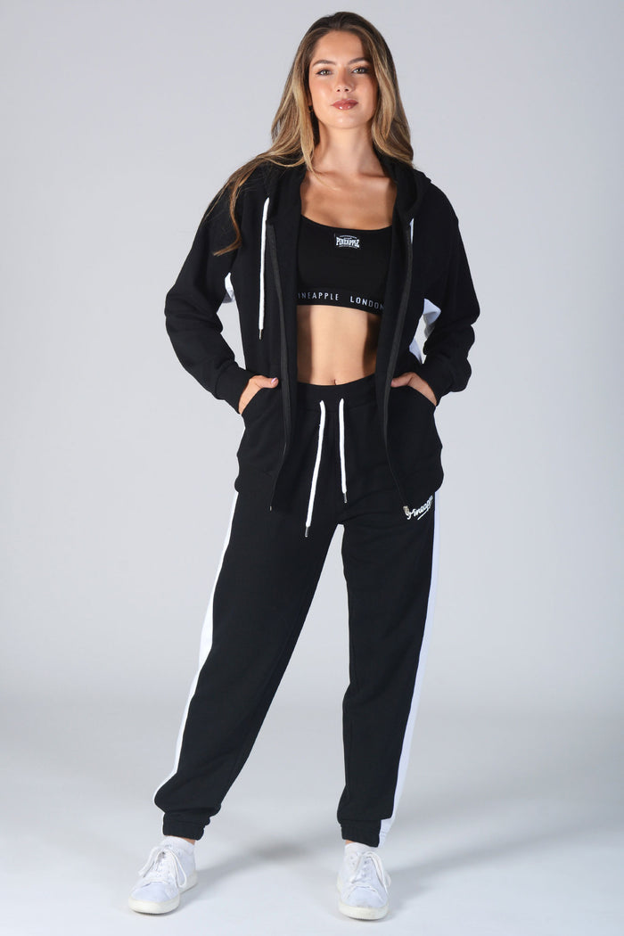 Woman wearing black Zip Hoodie and matching jogging trousers with white drawstring hood and waist