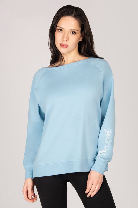 Woman wearing a light blue sweater on a plain background