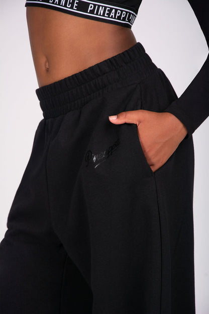 Girl wearing black joggers with pockets on a white background
