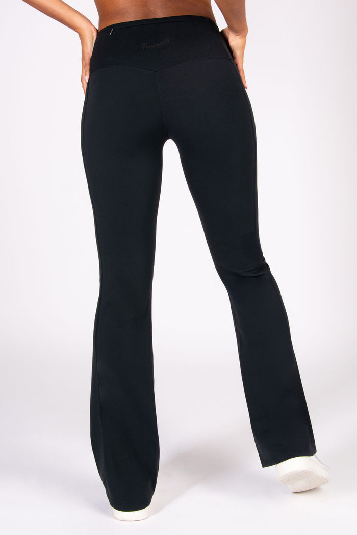 Women wearing black flared yoga pants against a white background