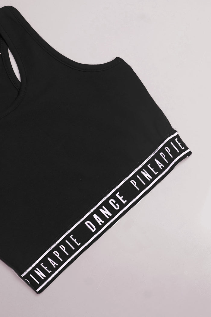 Detailed shot of Pineapple branded tape hem on midi crop top for girls.