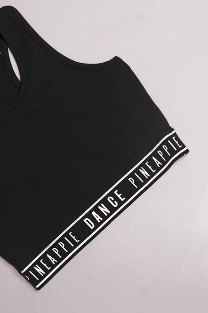 Detailed shot of Pineapple branded tape hem on midi crop top for girls.