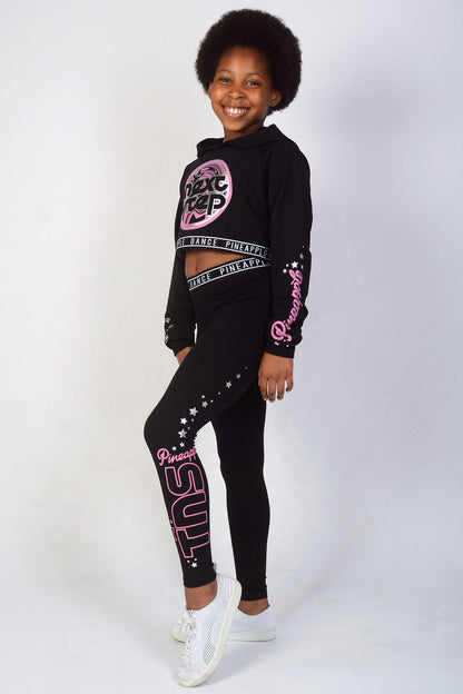 Girl wearing Black The Next Step Crop Hoodie and matching jacquard leggings with pink logos
