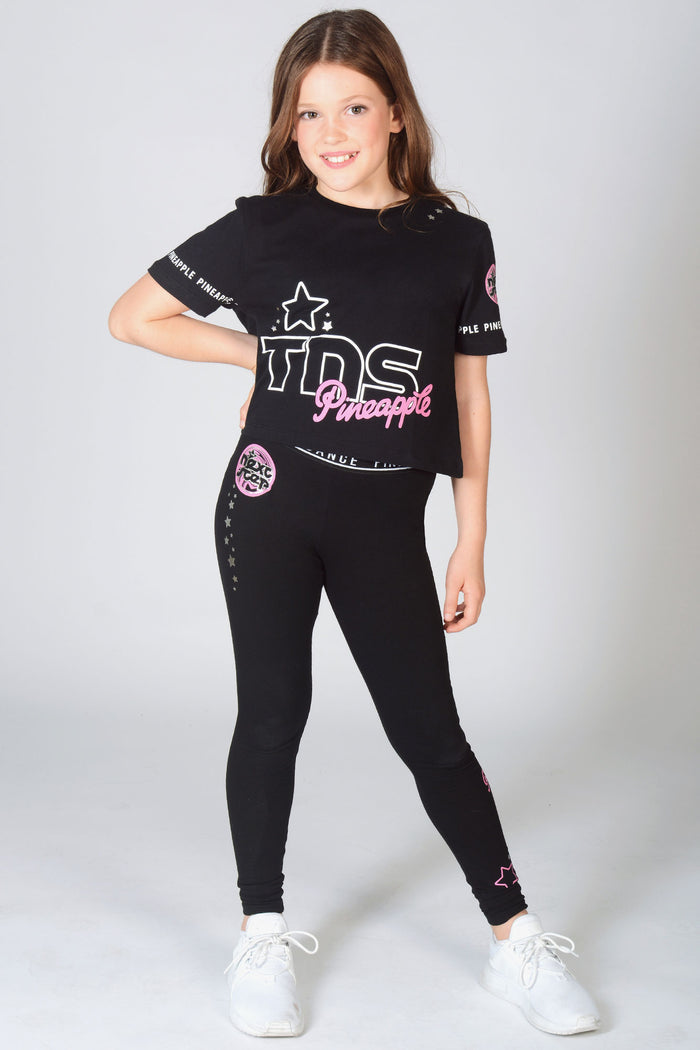 Young dancer wearing black TNS Crop T-Shirt with matching The Next Step Star Leggings in black.