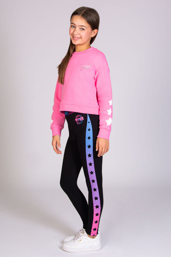 The ultimate The Next Step dance outfit for girls, complete with TNS pink jumper and a pair of black leggings with stars panel.