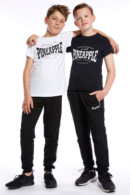 Boy wearing white and black Unisex Dance T-Shirt and track pants