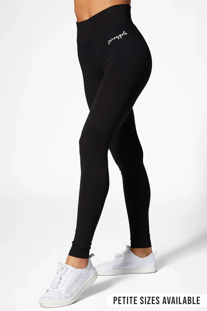 a woman wearing black cotton leggings on a white background