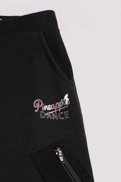 Detail of Pineapple Dance hip logo and zip pocket of black wide leg cargo joggers for girls.