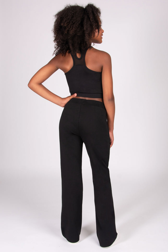 Girls wearing a black outfit with wide-leg pants on a white background