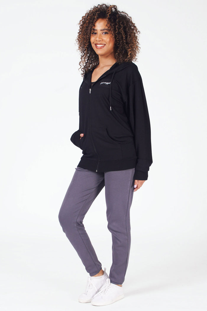 Woman wearing black zip front hoodie with small white logo